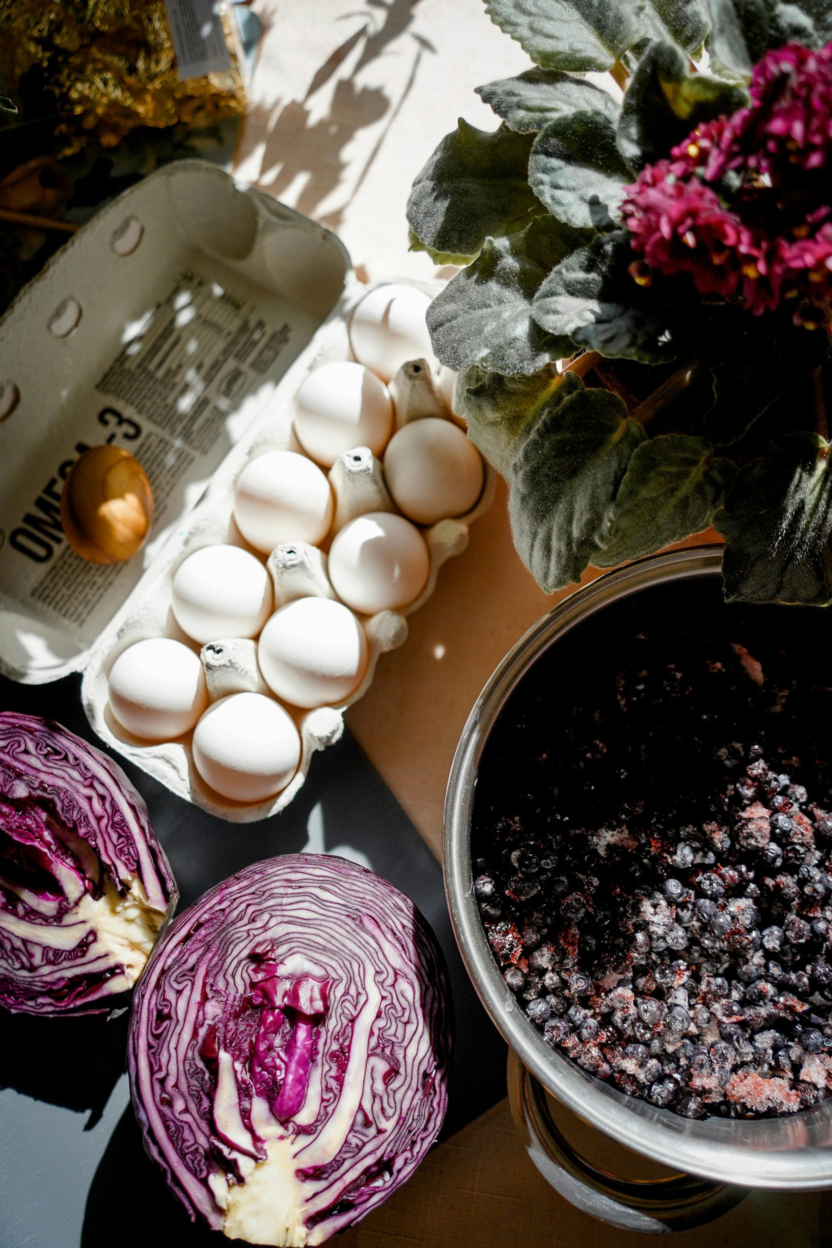 A flat lay of eggs, cabbage, and berries for natural Easter egg dyeing.